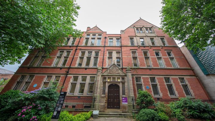 Upward view of a university building surrounded by trees