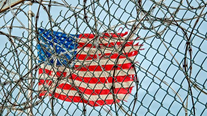 American flag seen through a wire fence
