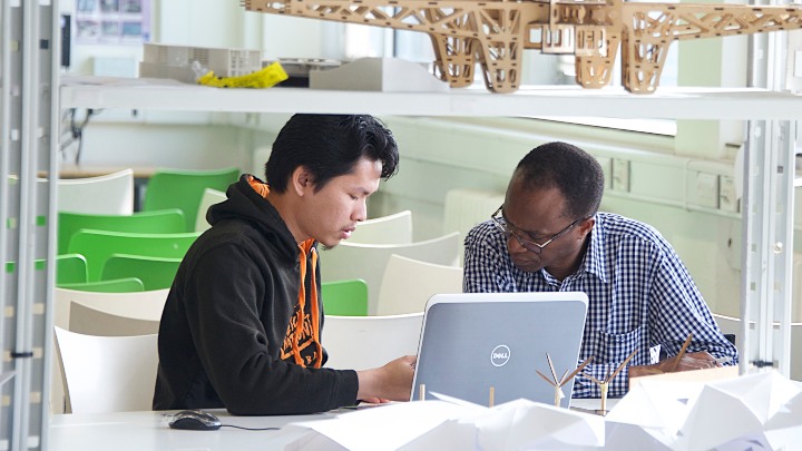 Student and supervisor looking at a laptop