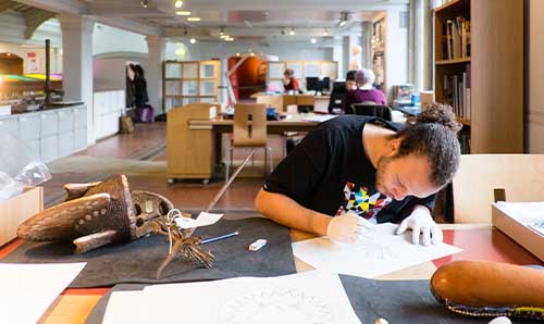 Student working with archaeology artefacts at the museum