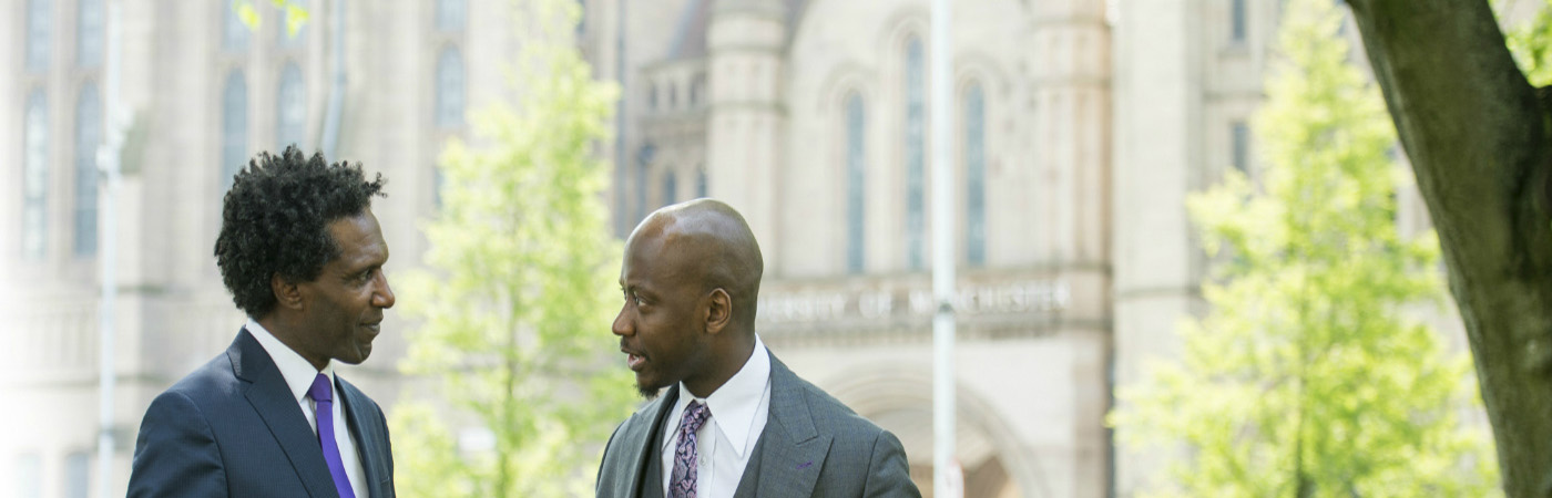 A photo of Lemn Sissay talking to barrister Tunde Okewale.