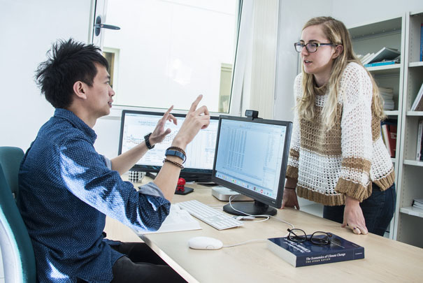 Two people talking round a desk