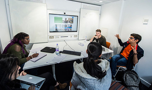 Students sat around a table in discussion