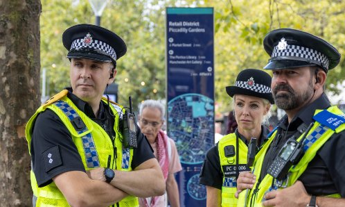 Police stood in Manchester Piccadilly Gardens.