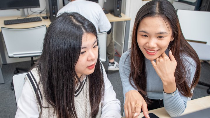 Two students looking at a computer screen 