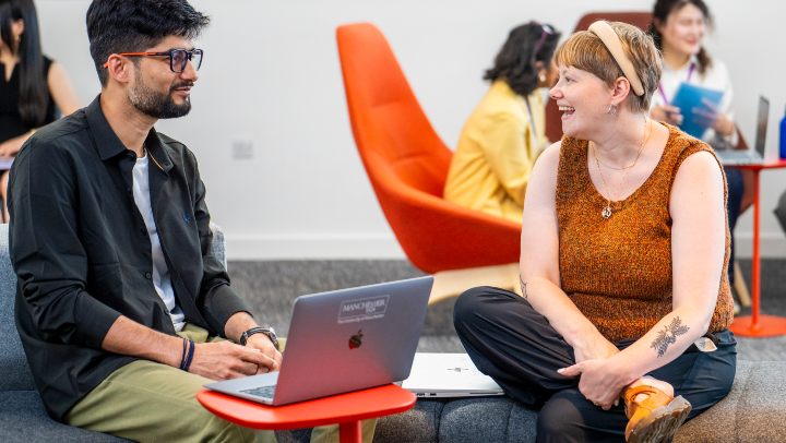 Pair of students chatting with laptops
