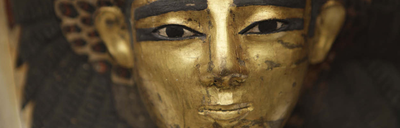 The face of a mummy on a sarcophagus.