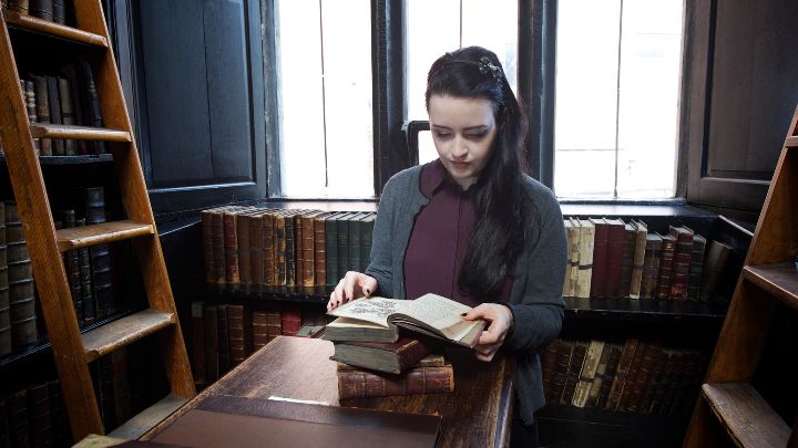 Student reading a book in a library