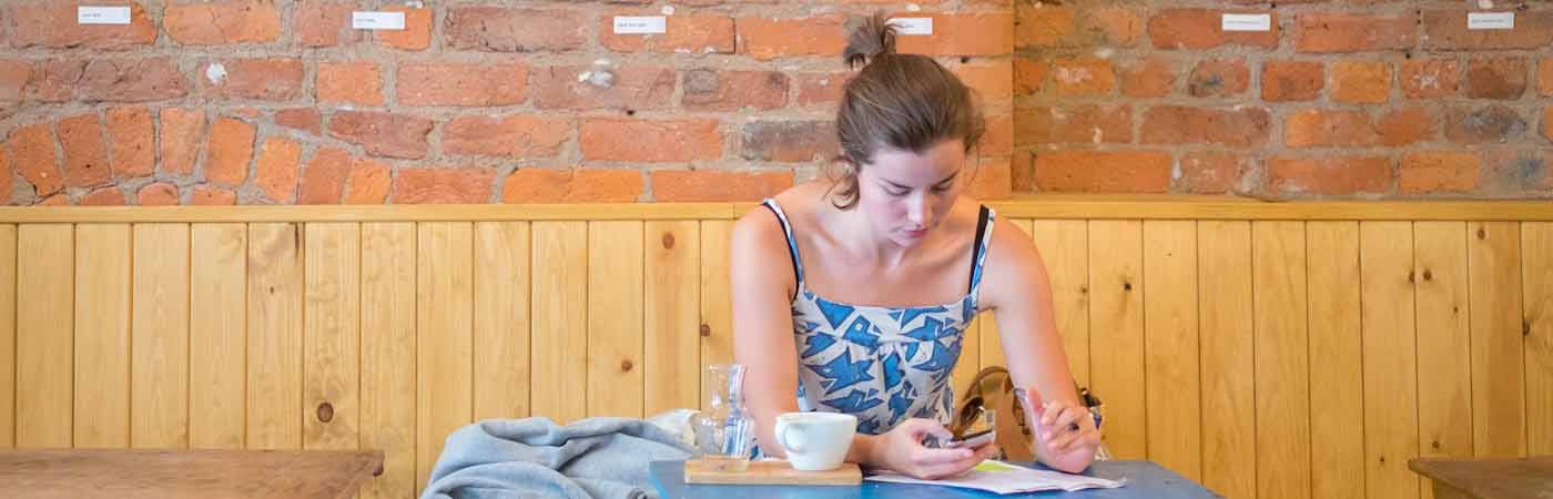 Student in cafe looking at phone