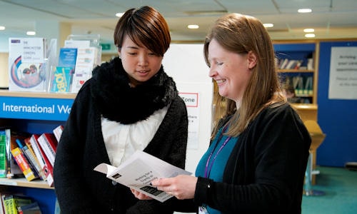 Student looking at leaflet with careers advisor