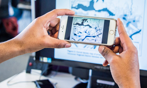 Student taking a picture of a map on mobile phone