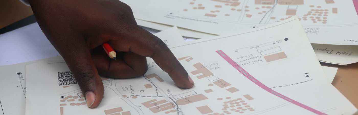 A hand pointing to plans on paper