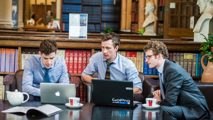 Law students sat with laptops in university library