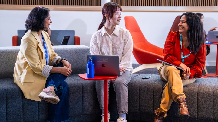 Postgraduate students chatting around a table 