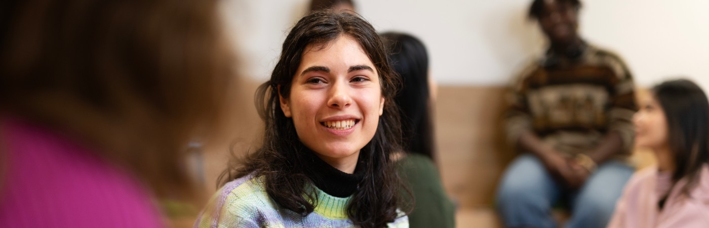 Student sat smiling at another student