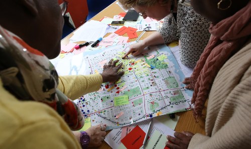Two people pointing at a map of Manchester.