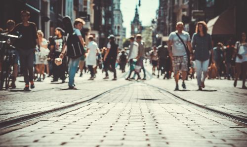 People walking on tram lines in Manchester.