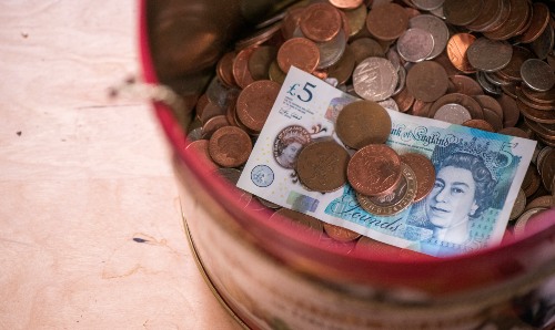 A pot containing loose change and a five pound note