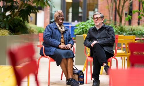 Two MUARG colleagues sitting down and laughing.
