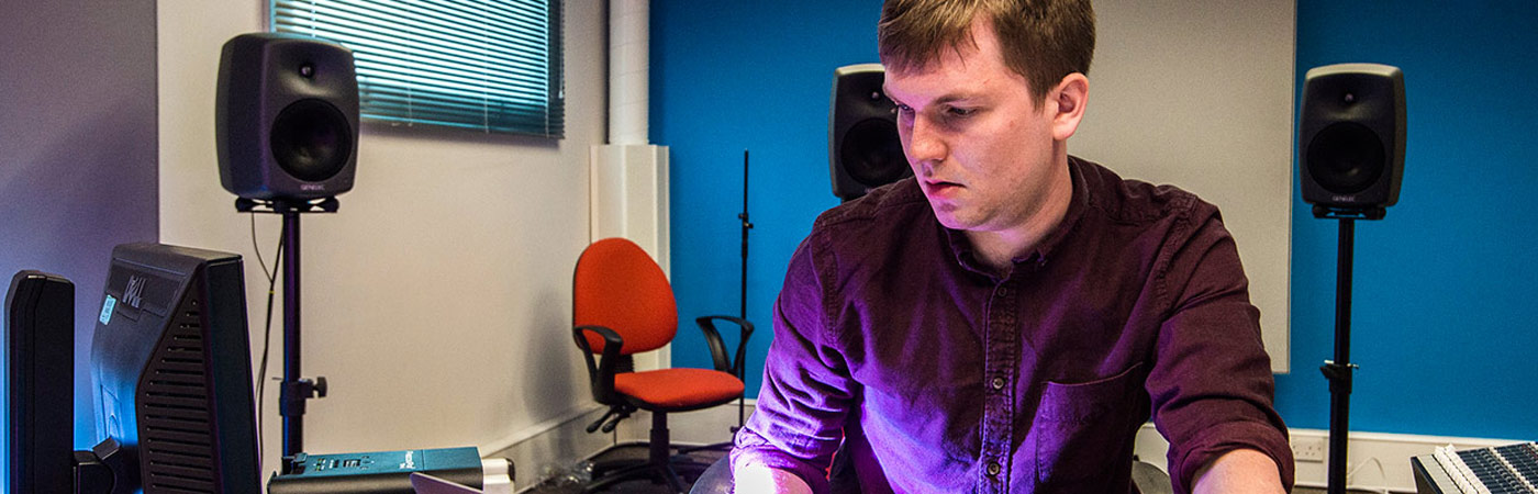Male student at a mixing desk in the electroacoustic studio