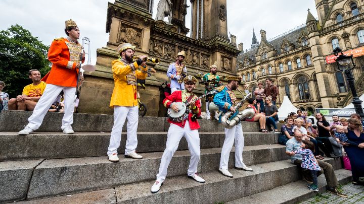Musicians playing in front of a crowd in Manchester city centre