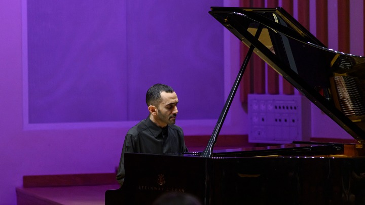 Male student playing the piano.