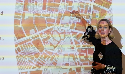 Female lecturer pointing at a map.