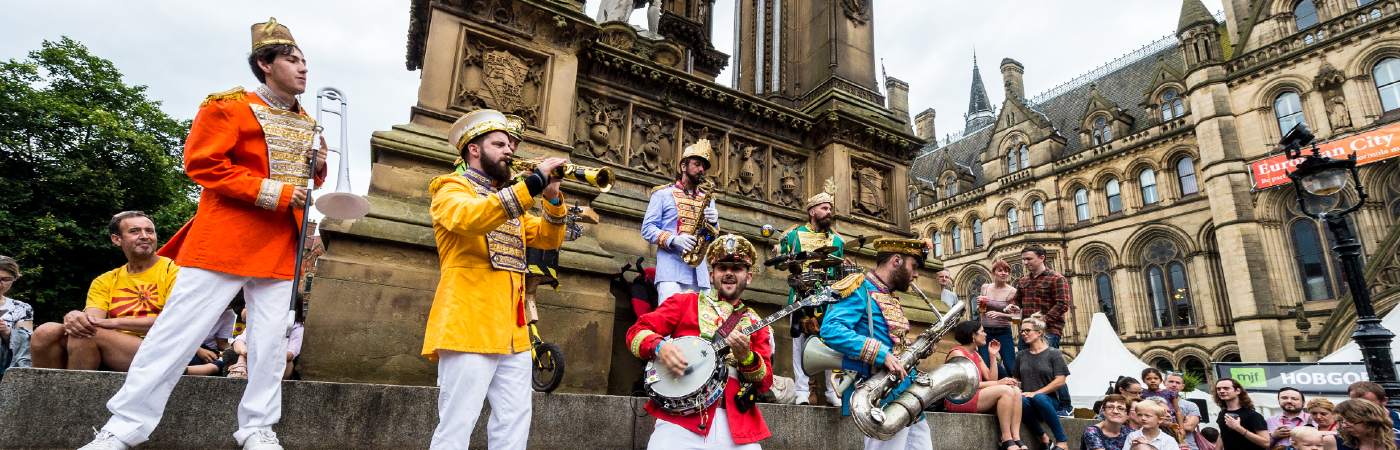 Band playing in front of a crowd in Manchester city centre.