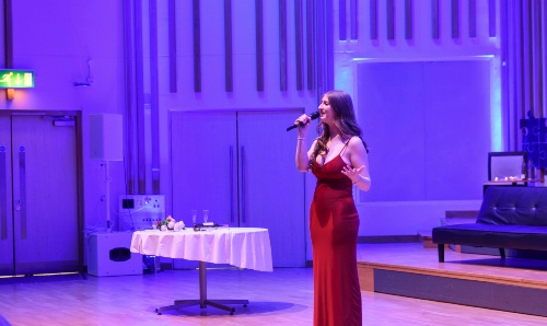 Female student singing on stage.