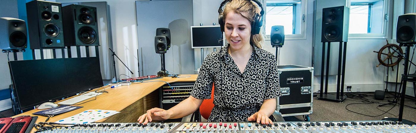 Female student at a mixing desk in the electroacoustic building