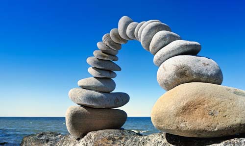 An arch of pebbles in front of an ocean landscape