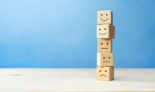 Wooden blocks with symbols of different emotions on them.