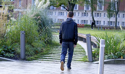  A male student walking through campus grounds