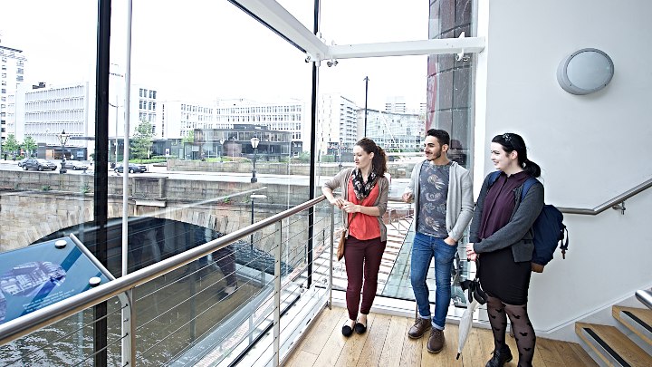 Group of students standing by a window