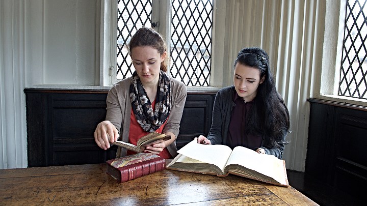 Student and supervisor looking through textbooks
