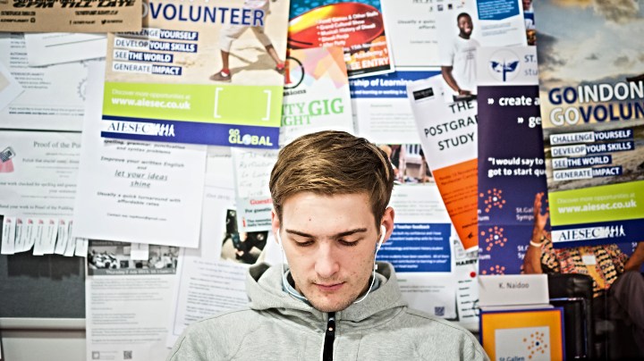 Student sat infront of a careers notice board