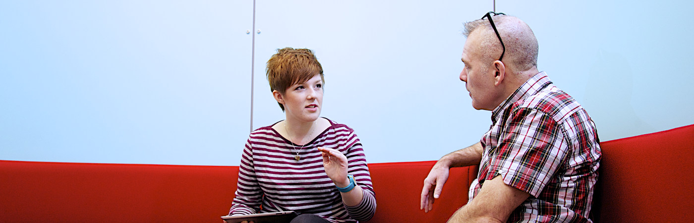 Two people in conversation sat in a study area