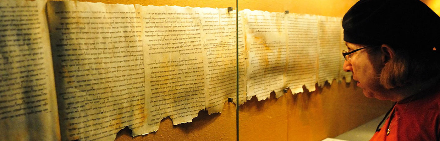 Woman looking at old scrolls in display cabinet