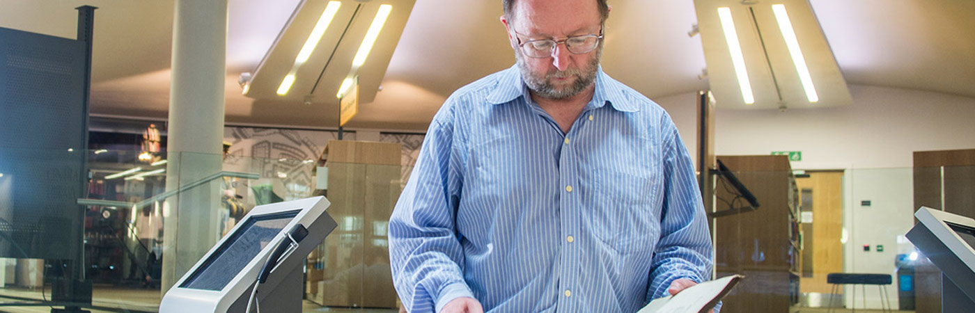 University academic in library reading old text