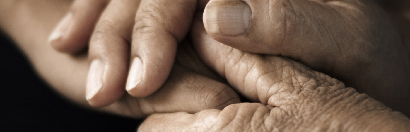 Elderly hands being held