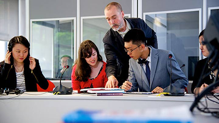 Students with teacher looking over their work