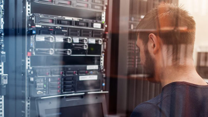 IT Engineer with thin aluminium laptop in network server room