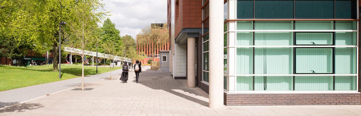 Students walking by the Arthur Lewis building on The University of Manchester campus