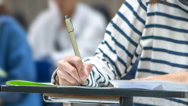 Close up of student writing in a lecture.
