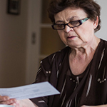 Elderly lady checking a bill