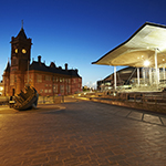 Buildings in Wales with a wrecked boat in front.