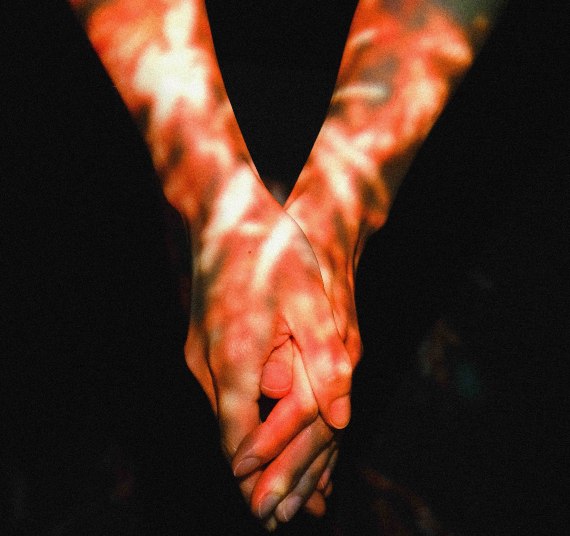 From the grasp grasp collection, two hands holding each other in distorted light.