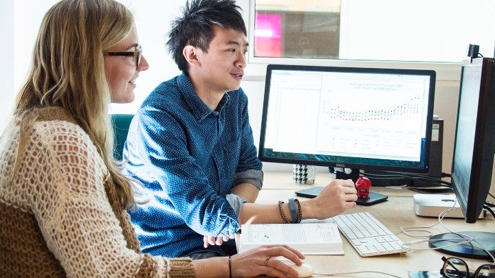 Student and supervisor sat looking at computer screens 