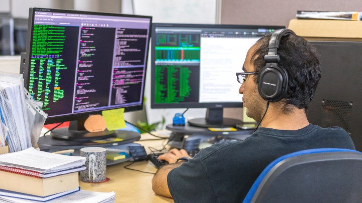 Student sat looking at computers screens 