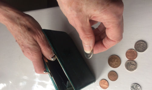 Hands holding a purse with some change